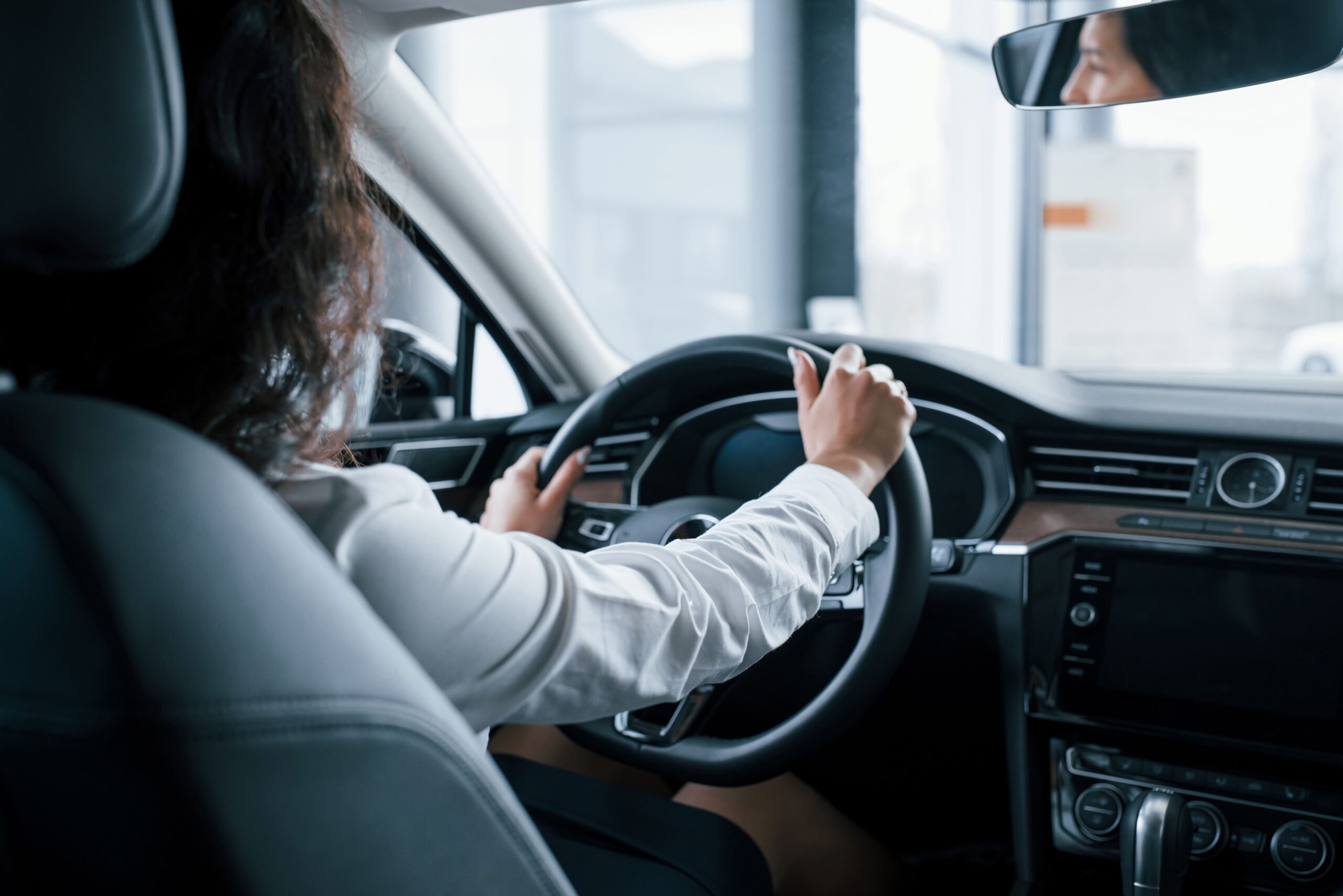 hands-on-steering-wheel-beautiful-businesswoman-trying-her-new-car-in-the-automobile-salon